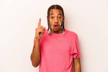 Beyaz arka planda izole edilmiş genç Afro-Amerikalı adam ağzı açık bir şekilde üst tarafı işaret ediyor..