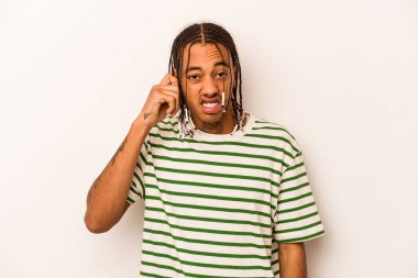 Genç Afrikalı Amerikalı bir adam beyaz arka planda izole edilmiş parmaklarıyla kulaklarını kapatan, yüksek sesli bir ortam tarafından stresli ve umutsuz..