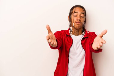 Beyaz arka planda izole edilmiş genç Afrikalı Amerikalı dudaklarını kıvırıyor ve hava öpücüğü yollamak için avuç içleri tutuyor..