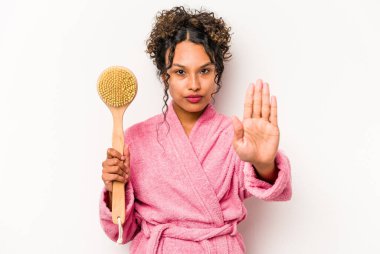 Beyaz arka planda izole edilmiş sırt kaşıyıcı tutan genç İspanyol kadın elini uzatmış, dur işareti göstererek seni engelliyor..