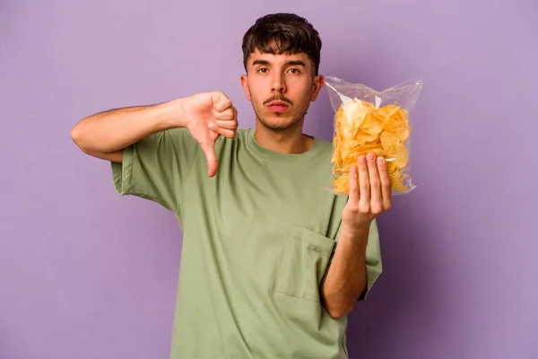 Een Jonge Spaanse Man Die Chips Een Paarse Achtergrond Vasthoudt — Stockfoto