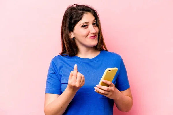 Ung Kaukasiska Kvinna Som Håller Mobiltelefon Isolerad Rosa Bakgrund Pekar — Stockfoto