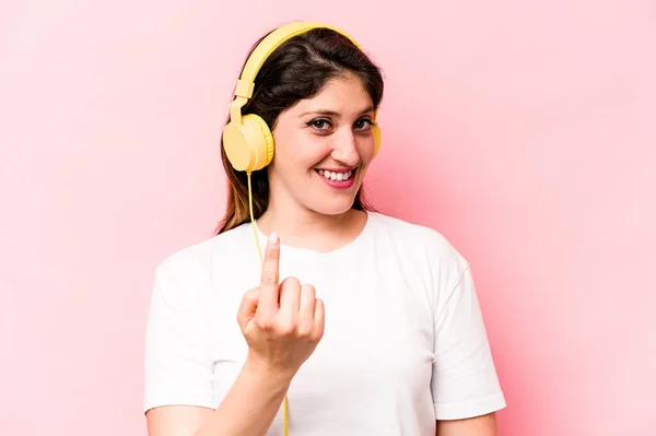Young Caucasian Woman Listening Music Isolated Pink Background Pointing Finger — Φωτογραφία Αρχείου
