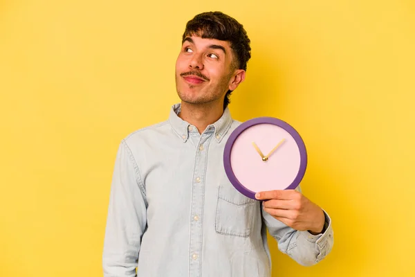 Молодий Іспаномовний Чоловік Тримає Годинник Ізольований Жовтому Тлі Мріє Досягти — стокове фото