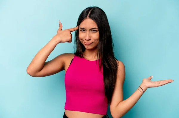 Ung Latinamerikansk Kvinna Isolerad Blå Bakgrund Håller Och Visar Produkt — Stockfoto