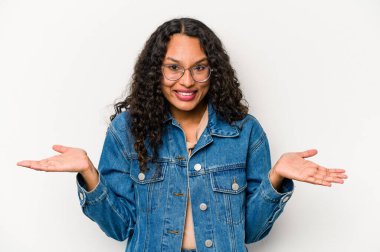 Beyaz arka planda izole edilmiş genç İspanyol kadın kollarıyla ölçeği yapıyor, mutlu ve kendinden emin hissediyor..