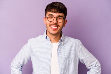 Mor arka planda izole edilmiş beyaz bir adam. Kendine güveniyor. Kalçaları tutuyor..