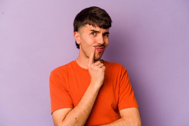 Mor arka planda izole edilmiş genç beyaz adam alaycı bir ifadeyle kameraya bakarken mutsuz oluyor..