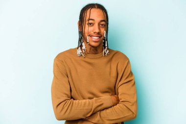 Genç Afrikalı Amerikalı adam mavi arka planda izole edilmiş gülüyor ve eğleniyor..