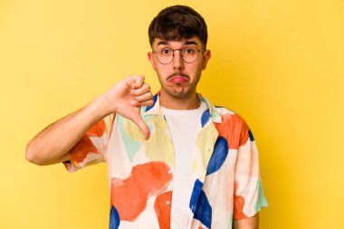Sarı arka planda izole edilmiş, hoşlanmadığı bir hareket gösteren beyaz bir genç. Anlaşmazlık konsepti.