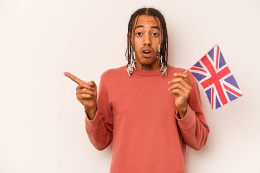 Beyaz arka planda izole edilmiş İngiliz bayrağı tutan genç bir Afro-Amerikan.