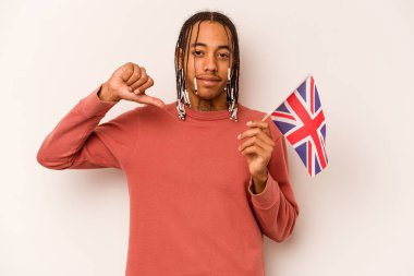 Beyaz arka planda izole edilmiş İngiliz bayrağı tutan genç bir Afrikalı Amerikalı gururlu ve kendinden emin hissediyor..