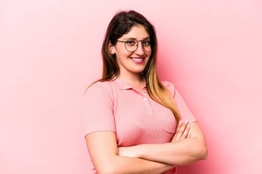 Pembe arka planda izole edilmiş genç beyaz kadın mutlu, güler yüzlü ve neşeli..