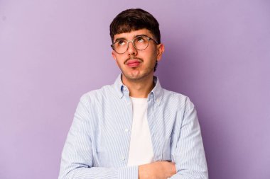 Mor arka planda izole edilmiş genç beyaz adam tekrarlanan bir görevden bıktı..