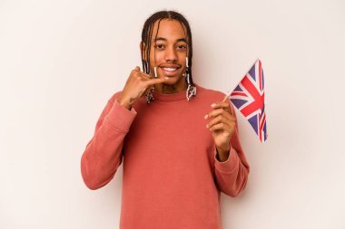 Beyaz arka planda izole edilmiş İngiliz bayrağı tutan genç bir Afro-Amerikan adam parmaklarıyla bir cep telefonu hareketi gösteriyor..