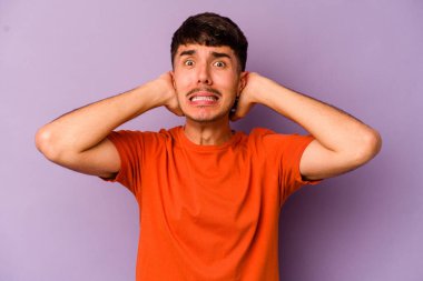 Mor arka planda izole edilmiş genç beyaz adam öfkeyle bağırıyor..