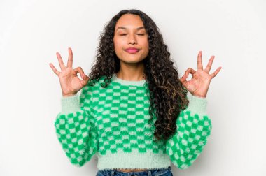 Beyaz arka planda izole edilmiş genç İspanyol kadın sıkı çalışma gününden sonra rahatlıyor, yoga yapıyor..