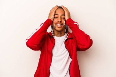 Beyaz arka planda izole edilmiş genç Afro-Amerikalı adam mutlu bir şekilde ellerini başının üstünde tutarak gülüyor. Mutluluk kavramı.