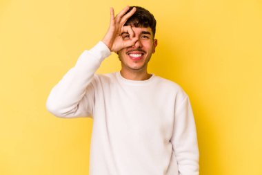 Kafkasyalı genç adam sarı arka planda izole edilmiş. Heyecanlı..