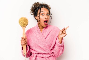 Beyaz arka planda izole edilmiş sırt kaşıyıcı tutan genç İspanyol kadın...