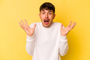 Sarı arka planda izole edilmiş genç beyaz adam gökyüzüne haykırıyor, yukarı bakıyor, hayal kırıklığına uğramış..