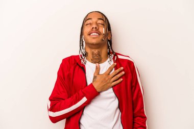 Beyaz arka planda izole edilmiş genç Afrikalı Amerikalı adam elini göğsüne koyduğunda kahkahalar atıyor..