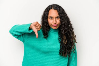 Beyaz arka planda izole edilmiş genç İspanyol kadın baş parmağını aşağı gösteriyor ve hoşlanmadığını ifade ediyor..