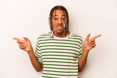 Beyaz arka planda izole edilmiş genç Afro-Amerikalı adam farklı kopya alanlarını gösteriyor, birini seçiyor, parmaklarıyla gösteriyor..