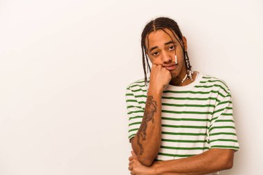 Beyaz arka planda izole edilmiş genç Afrikalı Amerikalı üzgün ve dalgın bir şekilde fotokopi odasına bakıyor..