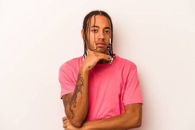 Genç Afrikalı Amerikalı adam beyaz arka planda izole edilmiş şüpheli, belirsiz, seni inceliyor..