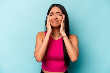 Genç İspanyol kadın mavi arka planda yalnız başına sızlanıyor ve ağlıyordu..