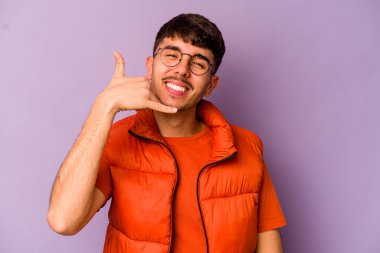 Mor arka planda izole edilmiş genç beyaz adam parmakları olan bir cep telefonu hareketi gösteriyor..