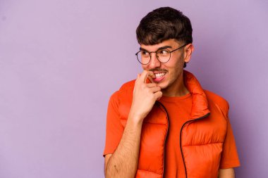 Mor arka planda izole edilmiş genç beyaz adam rahatlamış bir şeyin fotokopi odasına baktığını düşünüyor..