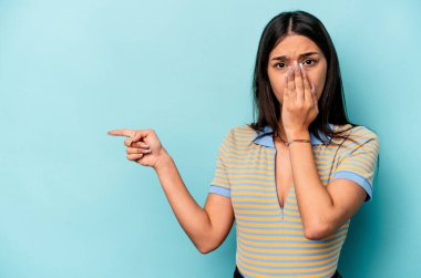 Mavi arka planda izole edilmiş genç İspanyol kadın...