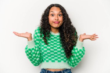 Beyaz arka planda izole edilmiş genç İspanyol bir kadın. Kafası karışmış ve omuz silkiyor. Kopya alanını tutmak için..