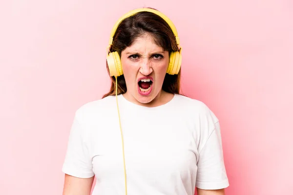 Νεαρή Καυκάσια Γυναίκα Που Ακούει Μουσική Απομονωμένη Ροζ Φόντο Ουρλιάζοντας — Φωτογραφία Αρχείου