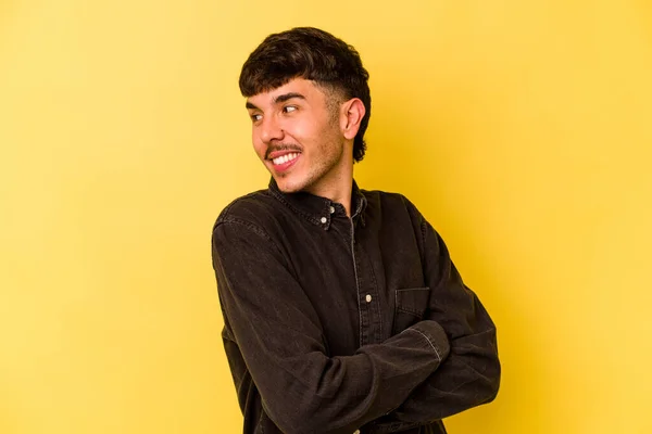 Young caucasian man isolated on yellow background laughing and having fun.