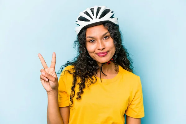 若いですヒスパニック女性身に着けていますヘルメット自転車隔離上の青の背景ショーナンバー2とともに指 — ストック写真