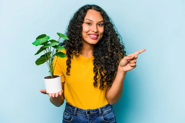 Ung Latinamerikansk Kvinna Håller Växt Isolerad Blå Bakgrund Ler Och — Stockfoto