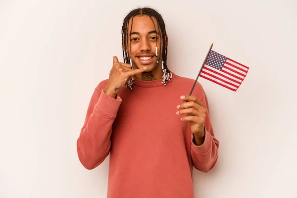 若いアフリカ系アメリカ人の男は白い背景に隔離されたアメリカの旗を持っている指で携帯電話の呼び出しジェスチャーを示す — ストック写真
