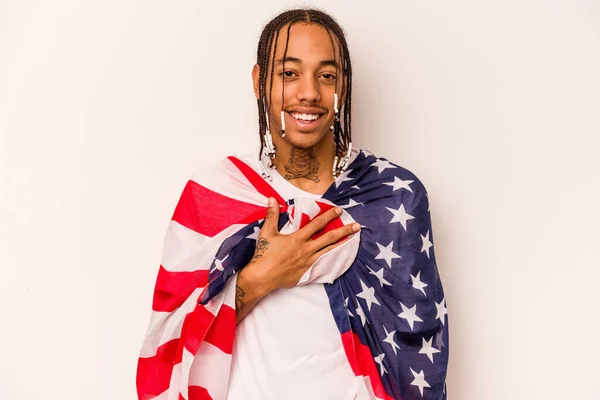 白い背景にアメリカ国旗を掲げた若いアフリカ系アメリカ人男性が大声で胸に手をつないで笑う — ストック写真