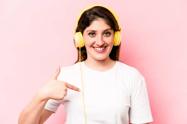 Young Caucasian Woman Listening Music Isolated Pink Background Person Pointing — Φωτογραφία Αρχείου