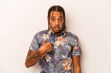 Beyaz arka planda izole edilmiş genç bir Afro-Amerikan erkeği parmağını gösterip gülümseyerek şaşırdı..