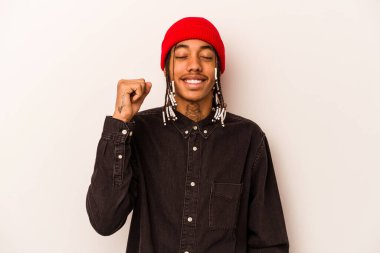 Genç Afrikalı Amerikalı adam beyaz arka planda izole edilmiş zafer, tutku ve coşkuyu kutluyor, mutlu bir ifade..