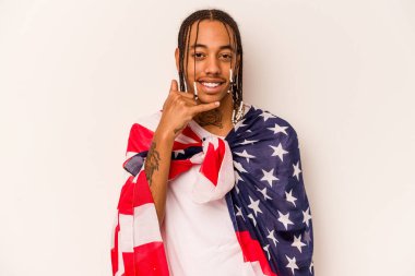 Beyaz arka planda izole edilmiş Amerikan bayrağı tutan genç bir Afro-Amerikan adam parmaklarıyla bir cep telefonu hareketi gösteriyor..