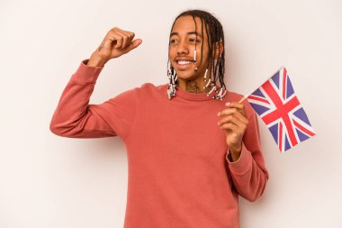 Beyaz arka planda izole edilmiş İngiliz bayrağı tutan genç bir Afrikalı Amerikalı zafer kazandıktan sonra yumruğunu kaldırıyor..