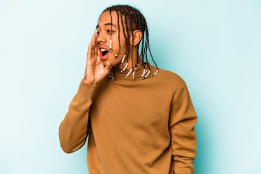Genç Afrikalı Amerikalı adam mavi arka planda izole edilmiş bağırıyor ve avuç içini açık tutuyor..