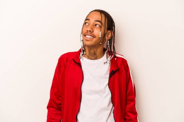 Beyaz arka planda izole edilmiş genç bir Afrikalı Amerikalı. Rahatlamış ve mutlu bir şekilde gülüyor. Dişlerini göstererek boynunu geriyor..