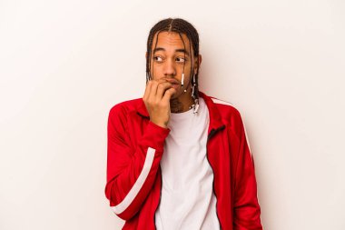 Genç Afrikalı Amerikalı bir adam beyaz arka planda izole edilmiş tırnak yiyor, gergin ve endişeli..
