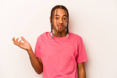 Genç Afrikalı Amerikalı, beyaz arka planda izole edilmiş. Sorgulama sırasında omuz silkiyor ve şüphe ediyor..